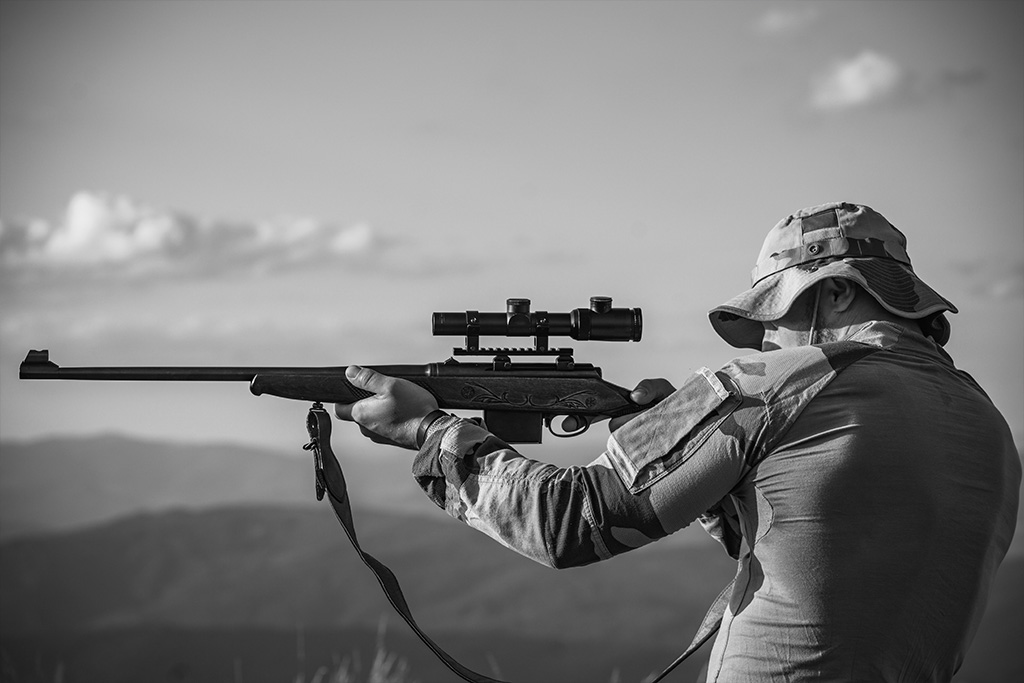 A Hunter Is Aiming Through the Bolt-Action Rifle Scope